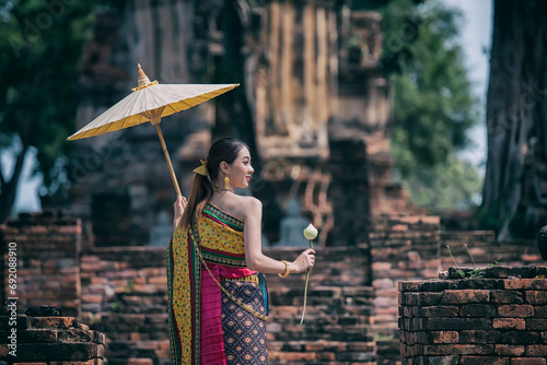 woman with umbrella. women in traditional clothing  on Buddhist on background.  Portrait women in traditional clothing , Thai traditional  in Ayutthaya, Thailand. photo