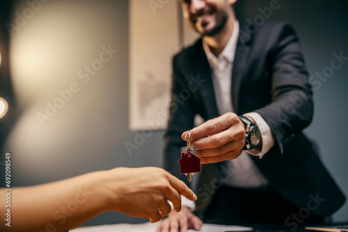 Close up of real estate broker giving house keys to a woman.