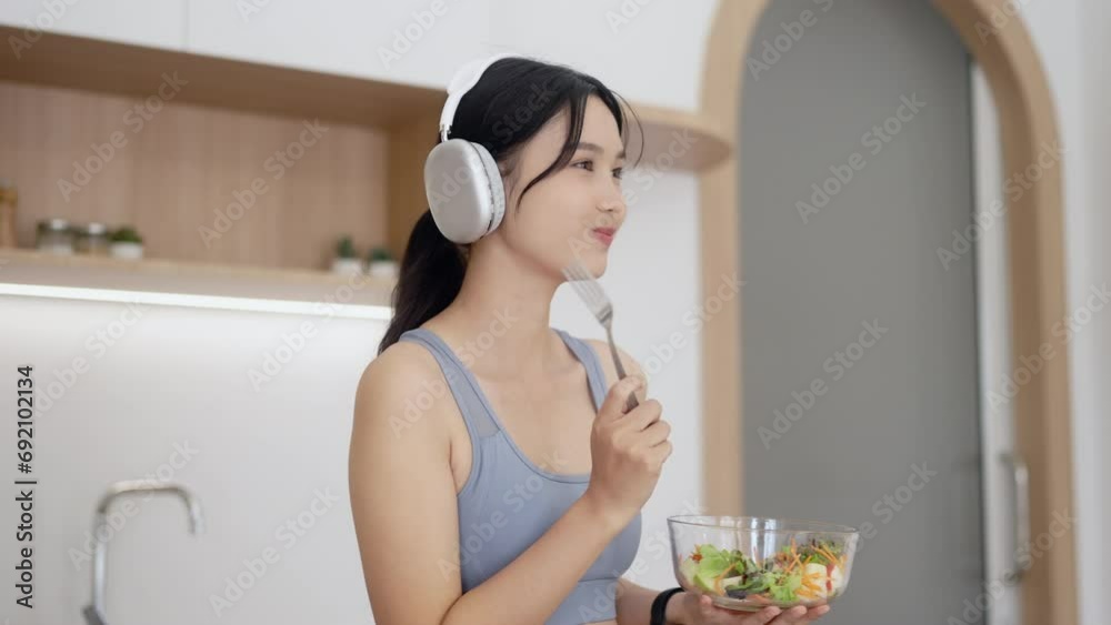 Young healthy woman eating bowl of fresh salad at her home. Young healthy woman eating bowl of fresh salad at her home.