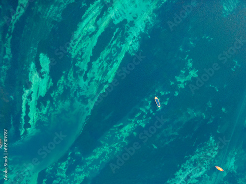 Aerial view of a boat cruising through algae-infested waters photo
