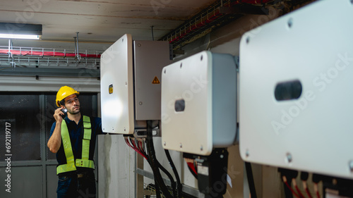 Technician Engineering setting inverter solar panel in electrical room. Service engineer installing solar cell on the roof of factory. Clean and Renewable energy concept. photo