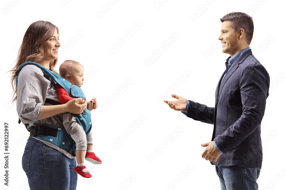 Profile shot of a man talking to a mother with a baby in a carrier Profile shot of a man talking to a mother with a baby in a carrier