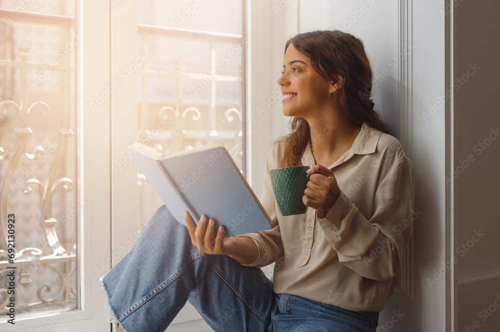 Relax Time. Beautiful young woman sitting on windowsill at home