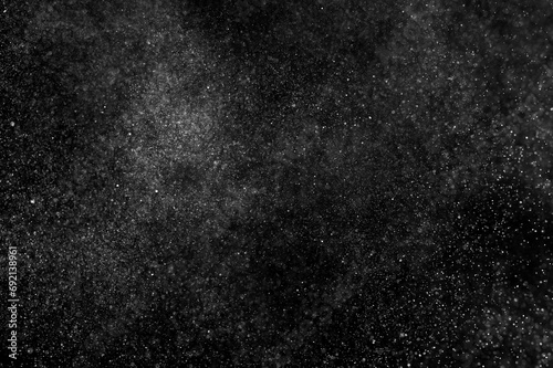 Abstract splashes of water on black background. Freeze motion of white particles. Rain, snow overlay texture.