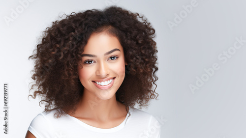 Beautiful brunette model african american girl with long curly hair. Smiling woman hairstyle wavy curly hair. Fashion, beauty and make up portrait. Copy space. 