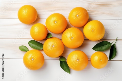 Fresh orange fruits with green leafs on white wooden background © Alina