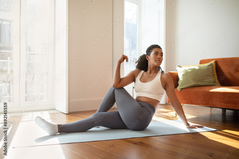 fitness woman practicing yoga doing seated spinal twists indoor - obrazy, fototapety, plakaty 