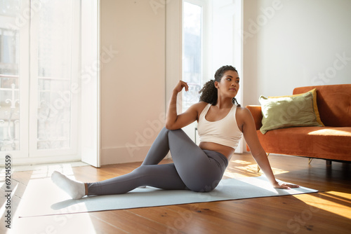 fitness woman practicing yoga doing seated spinal twists indoor photo