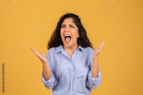 Sad despaired latin young brunette lady in casual with open mouth scream photo