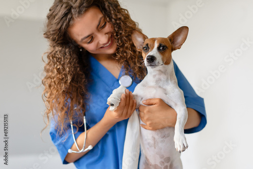 Obraz na plátně Curly-haired vet holding a small dog