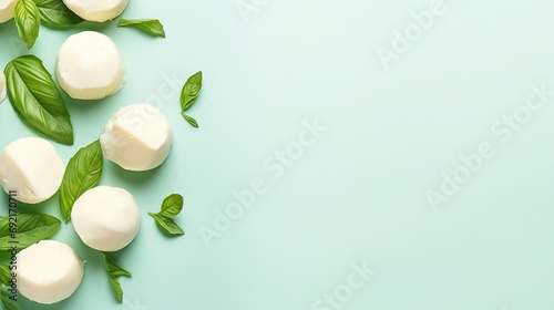 Mozzarella cheese with basil leaves on mint background. Top view, copy space © alionaprof