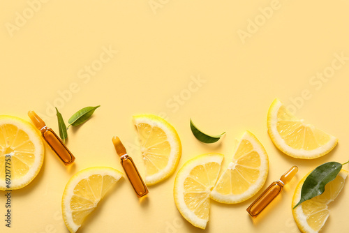 Ampoules with vitamin C and lemon slices on yellow background photo