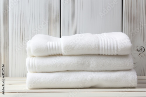 Stack of white folded towels on wooden background