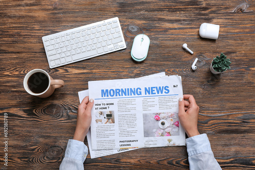 Woman reading newspaper at ...
