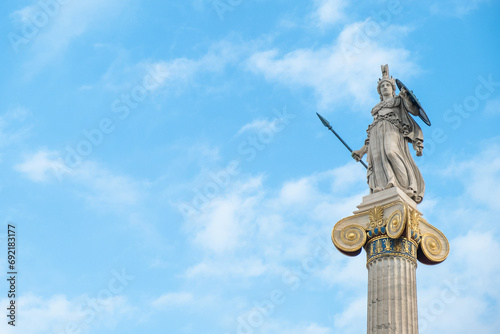 Statue of Athena on marble column from the Academy of Athens, Greece against blue sky. Popular landmark and travel destination