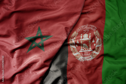 big waving national colorful flag of afghanistan and national flag of morocco .