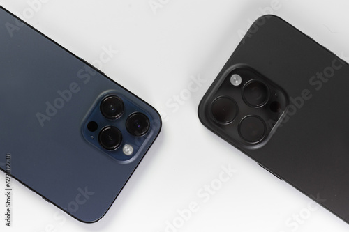 two smartphone cameras on a white background, , Iphone 15 pro max Black Titanium, iphone 12 pro max