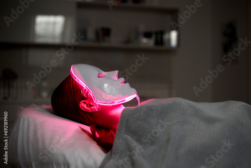 Photodynamic therapy. Cosmetic face mask. the girl is wearing a mask. Health and beauty. photo