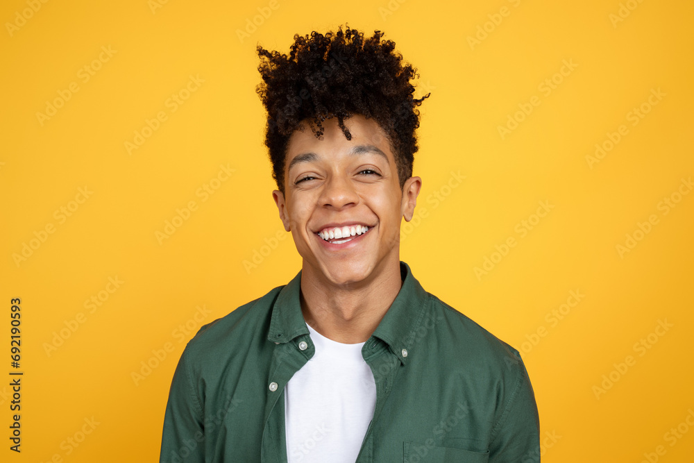 Portrait of laughing african american guy on yellow background Portrait of laughing african american guy on yellow background