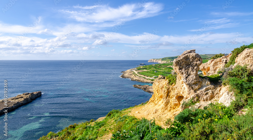 Mgarr, Malta - Panorama of Xatt l-Aħmar bay and cliffs in Malta at with beautiful colorful sky and golden rocks taken from near fort chambray