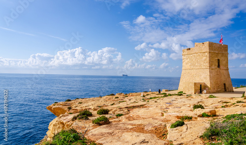 Torri Xutu. Ancient watch tower near Blue Grotto of Malta with Filfla island in a background.