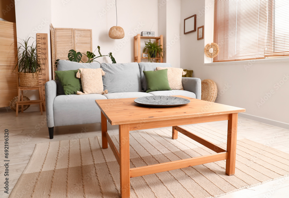 Interior of modern living room with grey sofa and wooden coffee table Interior of modern living room with grey sofa and wooden coffee table