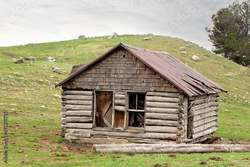 Фотография Abandoned and broken down ramshackle old antique homesteader log cabin home