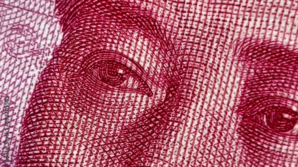 Close-up of intricate red and white guilloche pattern showing detailed eyes, typical for yuan banknote security features