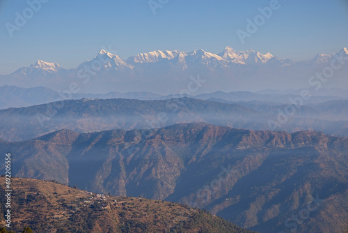 The distant snowcapped mountains of the Himalayas from the foothills near Nainital, Uttarakhand, India. photo