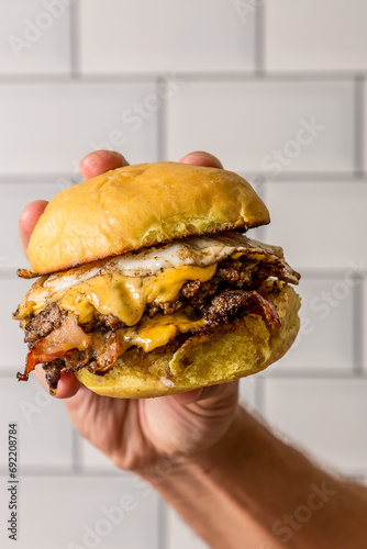 hamburger in hand double meat and cheddar cheese burger with fries