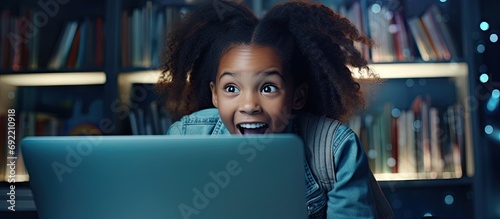 African teen schoolgirl sitting at desk learning studying use pc training materials received great news highest mark successfully pass exams or test at school accomplish homework feels happy ex photo