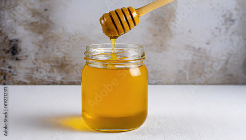 Honey in a glass jar with a wooden spoon dipper