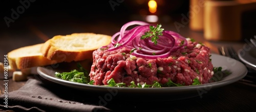 Beefsteak tartar with red onion rings ready to eat with toasted bread. Copy space image. Place for adding text or design photo