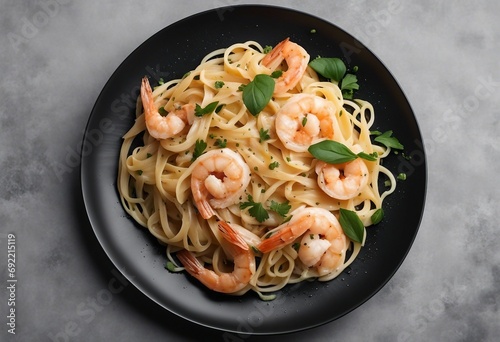 Italian pasta fettuccine in a creamy sauce with shrimp on a black plate top view