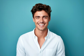 Portrait of a young man smiling at the camera on blue background with copy space for design