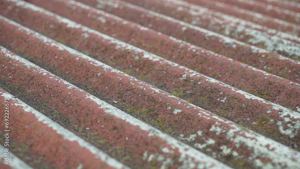 Mossy and peeled old red roof surface texture