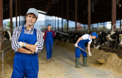 Portrait of positive male farm worker in a cowshed