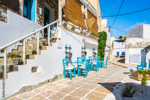 Tavern in narrow street with typical Greek style architecture in Kimolos village, Kimolos island, Cyclades, Greece