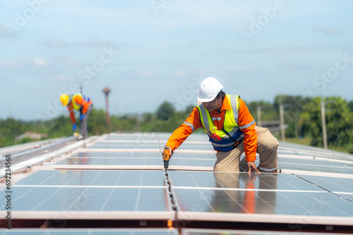 Engineer man is working to construct solar panels system on roof. Installing solar photovoltaic panel system. Alternative energy ecological concept. Renewable clean energy technology concept.