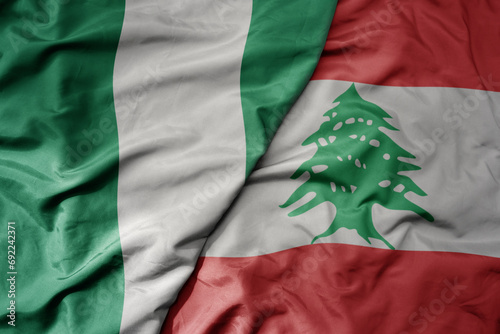 big waving national colorful flag of lebanon and national flag of nigeria . photo