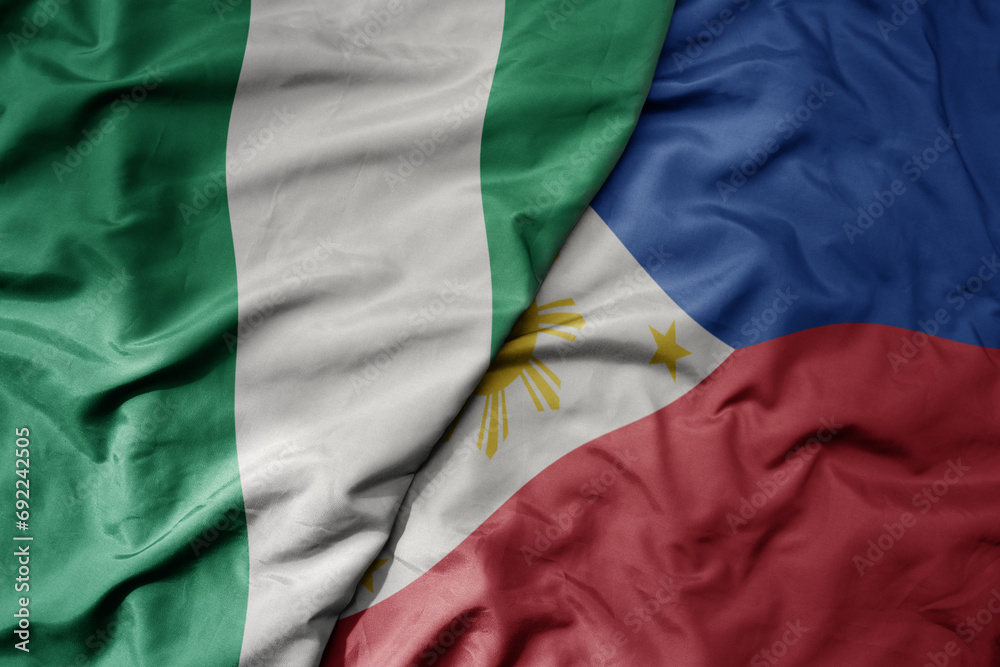 Obraz premium big waving national colorful flag of philippines and national flag of nigeria .