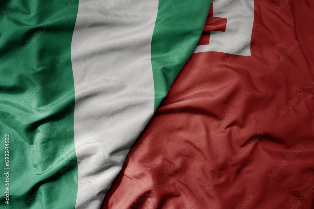 Obraz premium big waving national colorful flag of Tonga and national flag of nigeria .