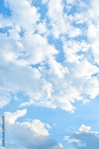 Imagen vertical de nubes blancas esponjosas en un cielo azul de dia photo