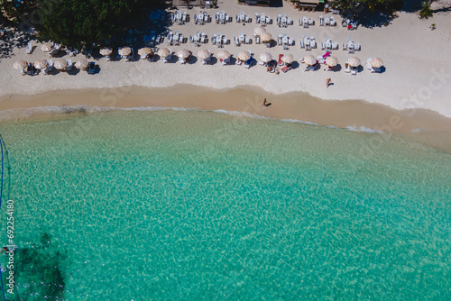 Koh Samet Island Thailand, aerial drone view from above at the Samed Island in Thailand with a turqouse colored ocean and a white tropical beach with beach chairs and umbrellas