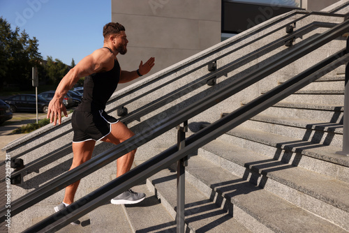Man running up stairs outdoors on sunny day