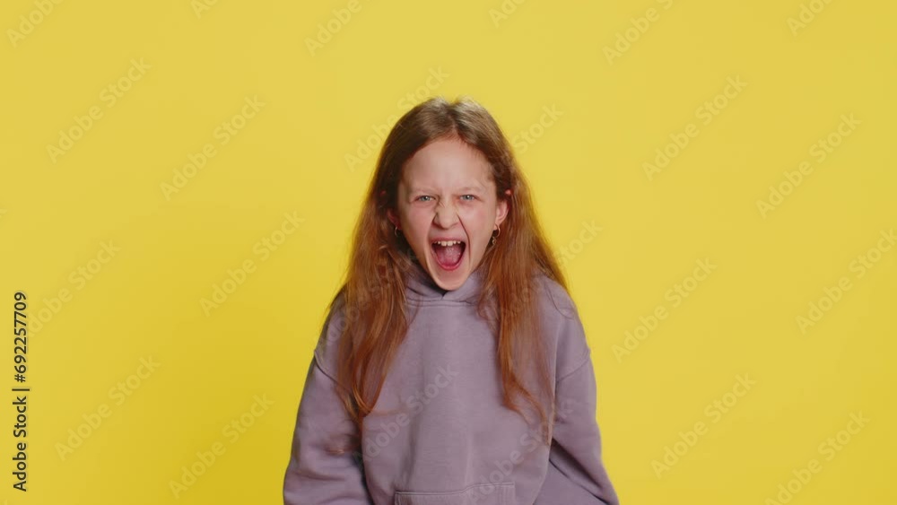 Irritated angry preteen child girl kid scream from stress tension problems feels horror hopelessness fear surprise shock expresses rage nervous quarrel. Teenager children isolated on yellow background Irritated angry preteen child girl kid scream from stress tension problems feels horror hopelessness fear surprise shock expresses rage nervous quarrel. Teenager children isolated on yellow background