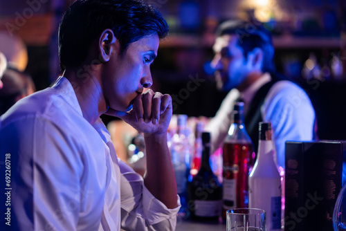 Asian depression man feeling heart broken and drinking beer in a bar.  photo