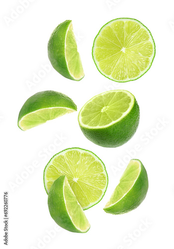 Cut fresh limes falling on white background