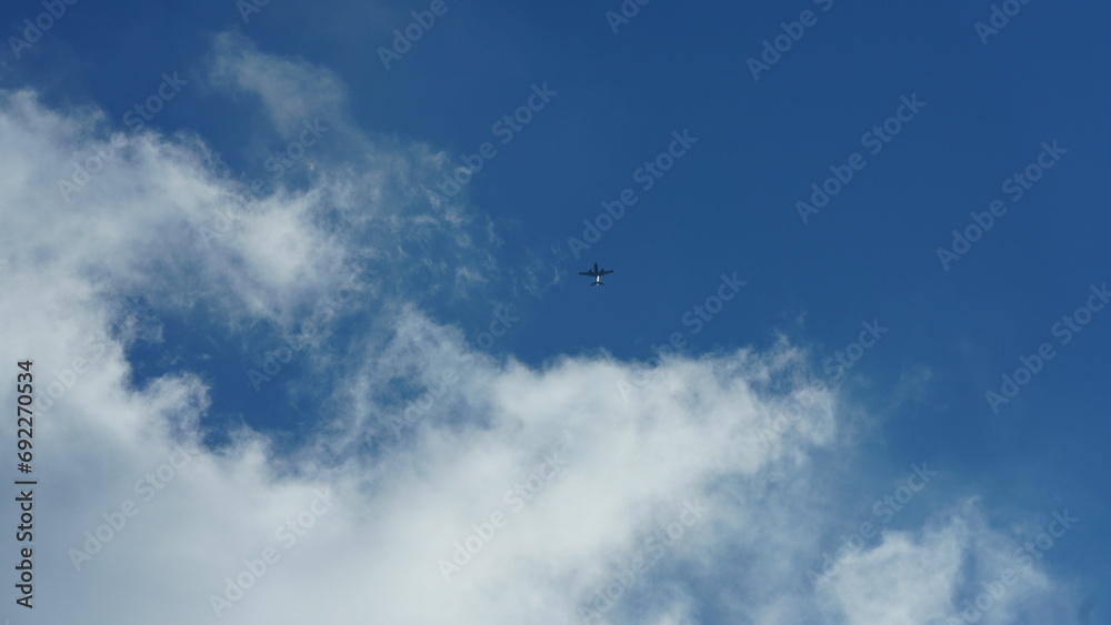 An airplane flying in the clear blue clouds sky An airplane flying in the clear blue clouds sky