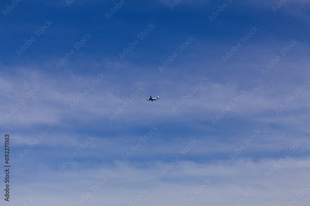 Distant Shot Of Commercial Airliner In Cloudy Blue Sky Distant Shot Of Commercial Airliner In Cloudy Blue Sky